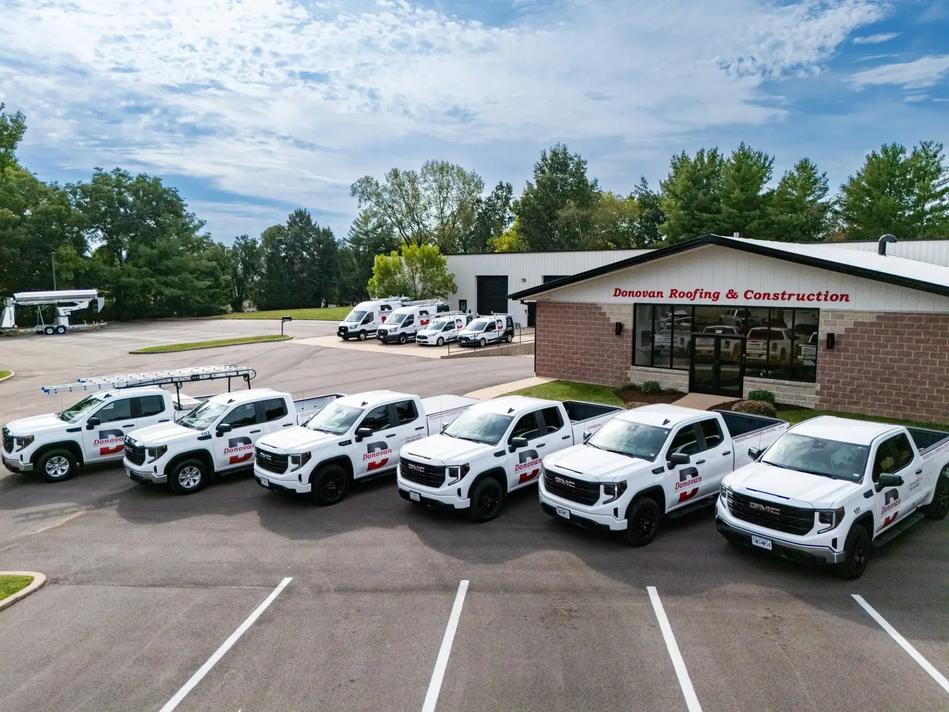 Donovan Roofing & Construction office with the company fleet of branded trucks lined up out front