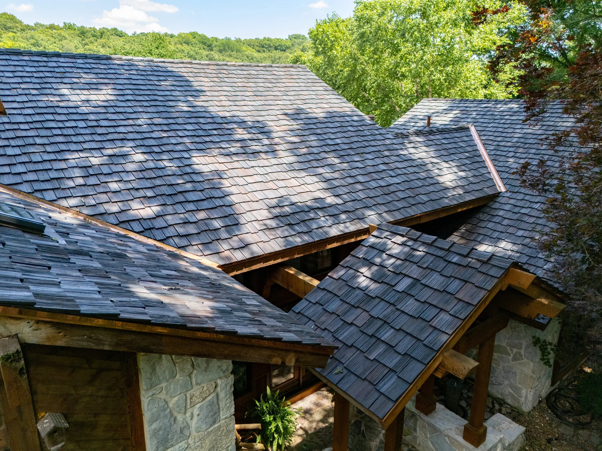 Shake courses meeting a stone chimney on a timber lodge home