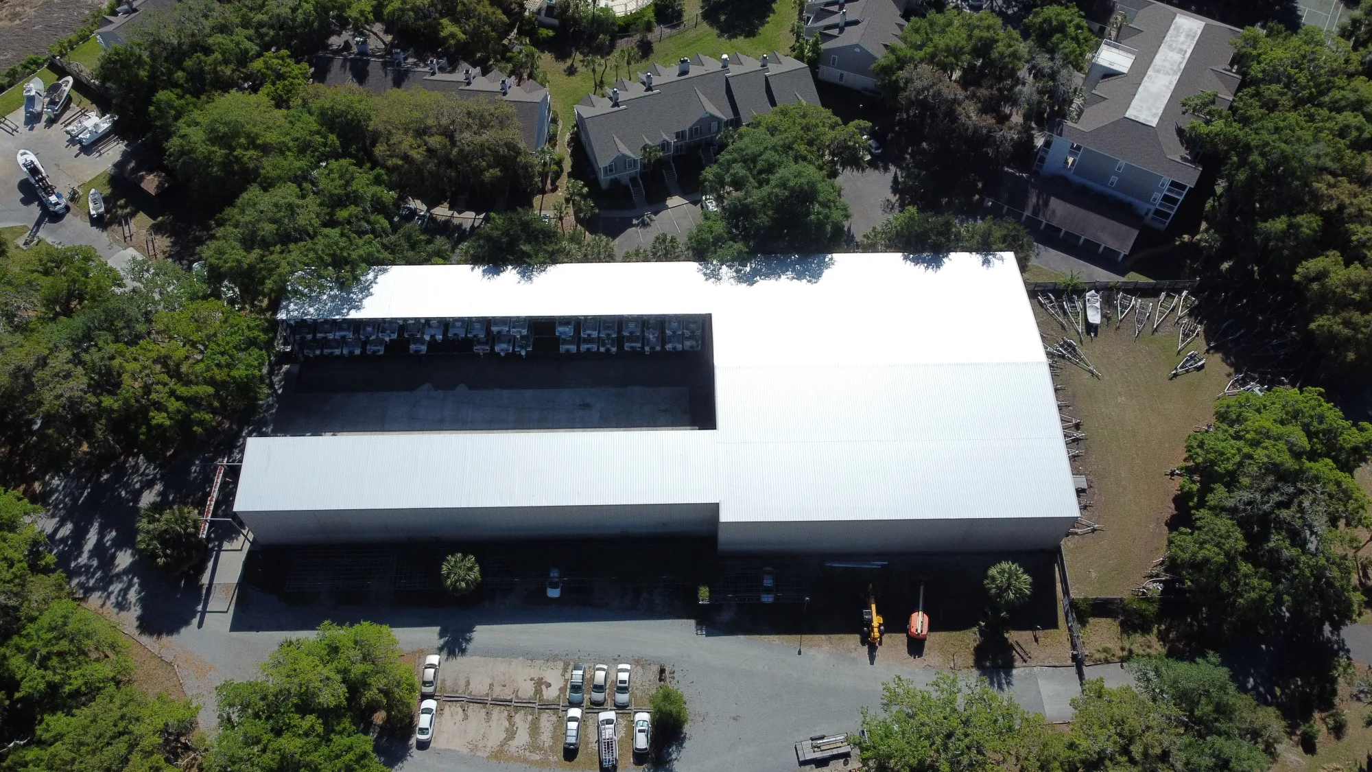 Aerial of a long low-rise industrial building with a dark membrane roof