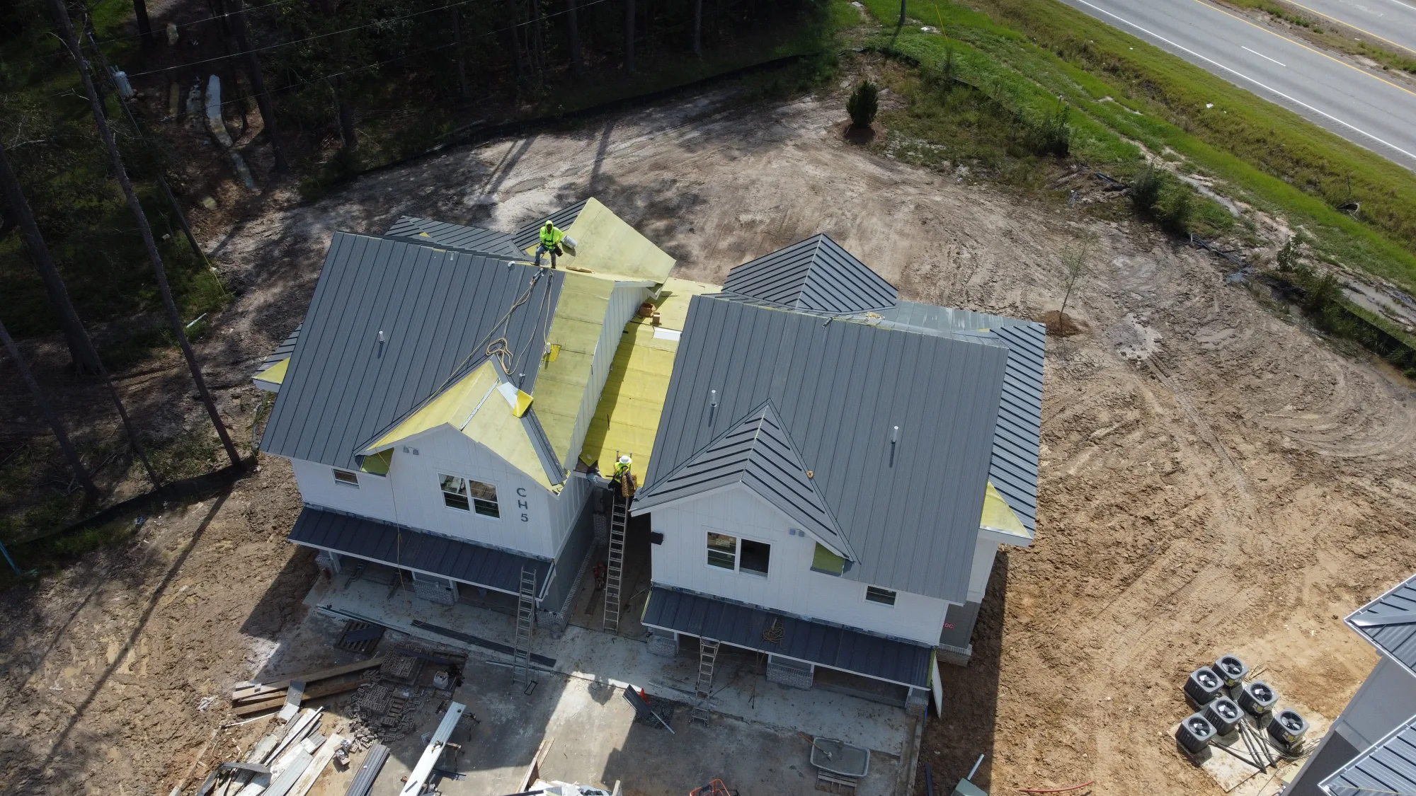 Aerial of a commercial building with newly installed gray standing seam metal panels