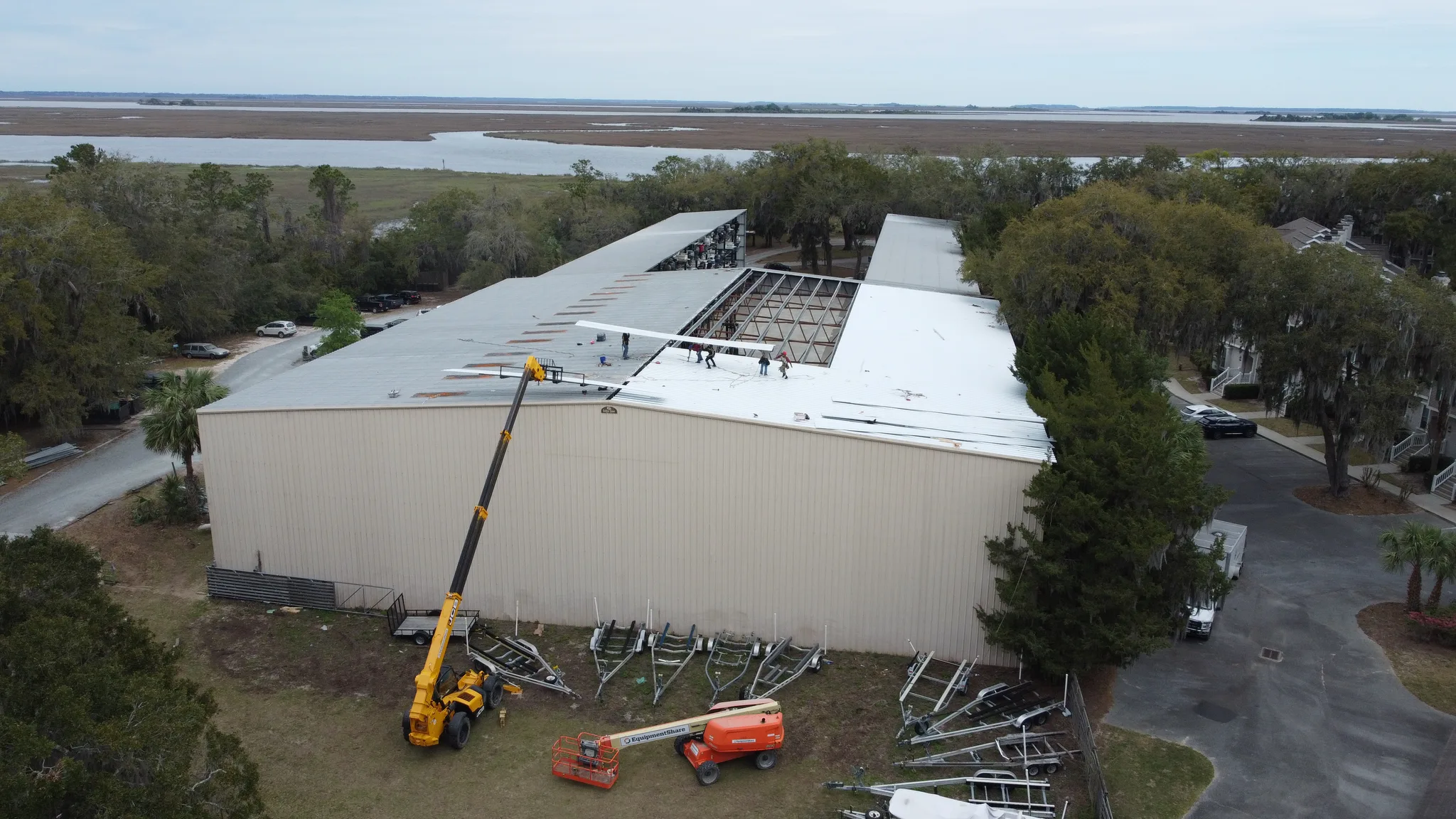 Large commercial marina reroof in progress with a crane and crew