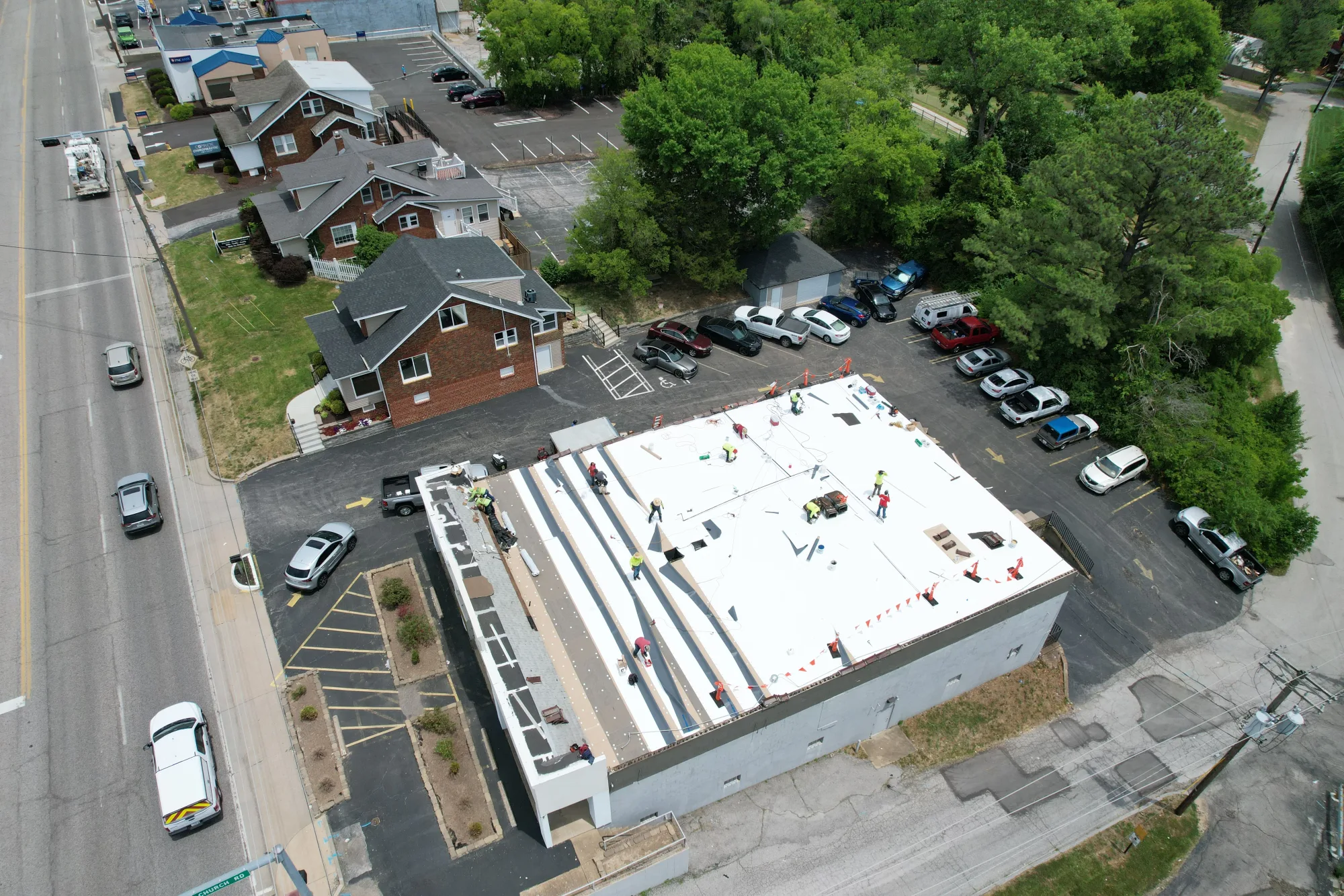 Crew finishing a white membrane roof on a commercial building