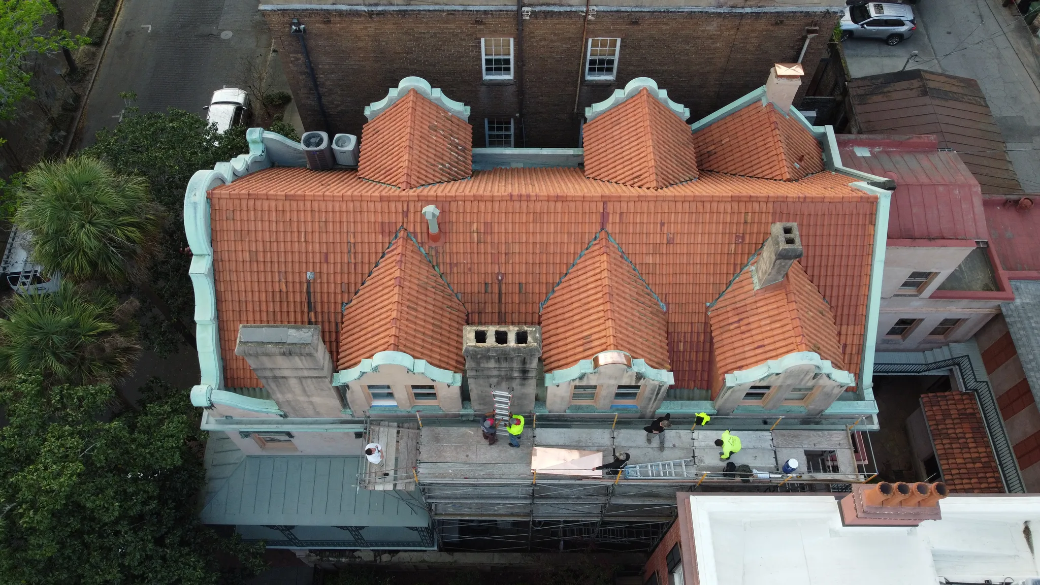 Crew restoring the clay tile and copper roof of a large historic institutional building