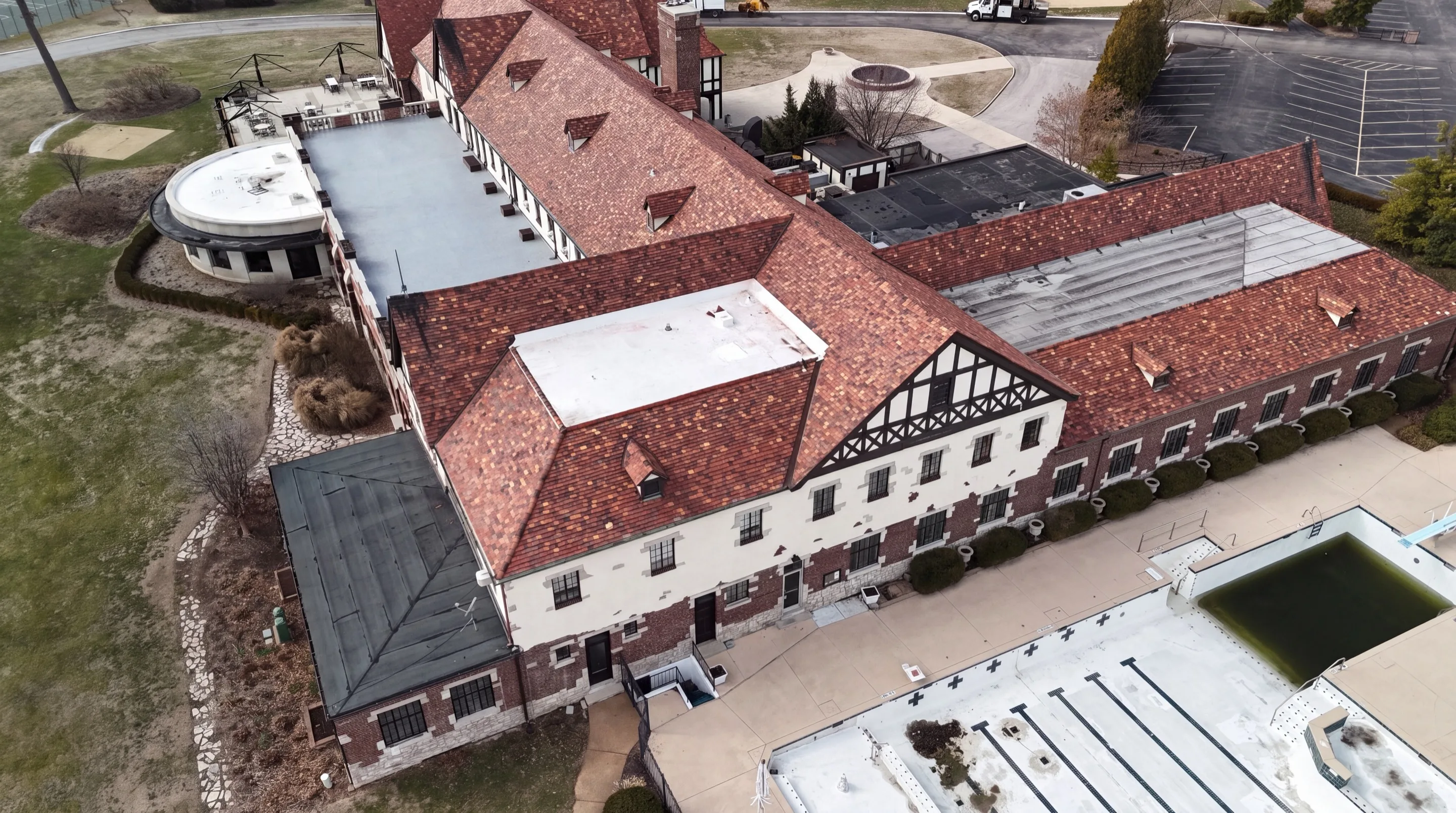 Aerial drone view of a commercial building complex with red clay tile roofs