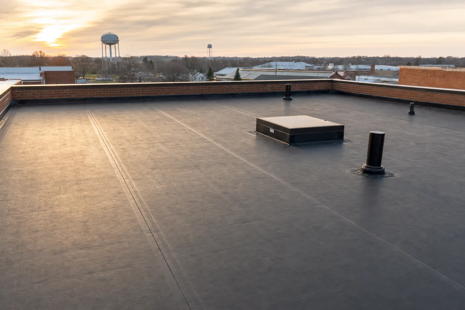 Wide view across the field of a finished black EPDM rubber roof