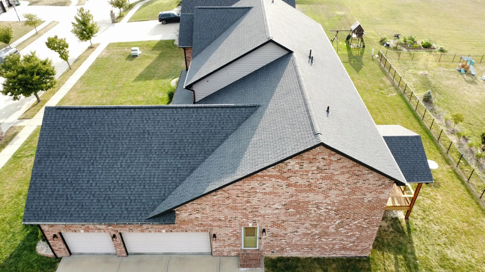 Aerial of a finished two-tone architectural shingle roof on a brick home with a detached garage, typical of the St. Louis Hills sloped-roof market