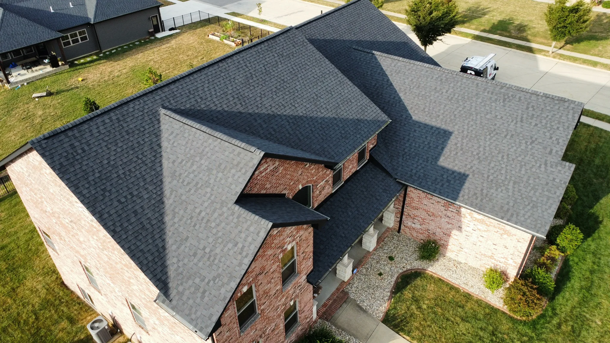 Aerial view of charcoal asphalt shingles on a brick Midwestern home