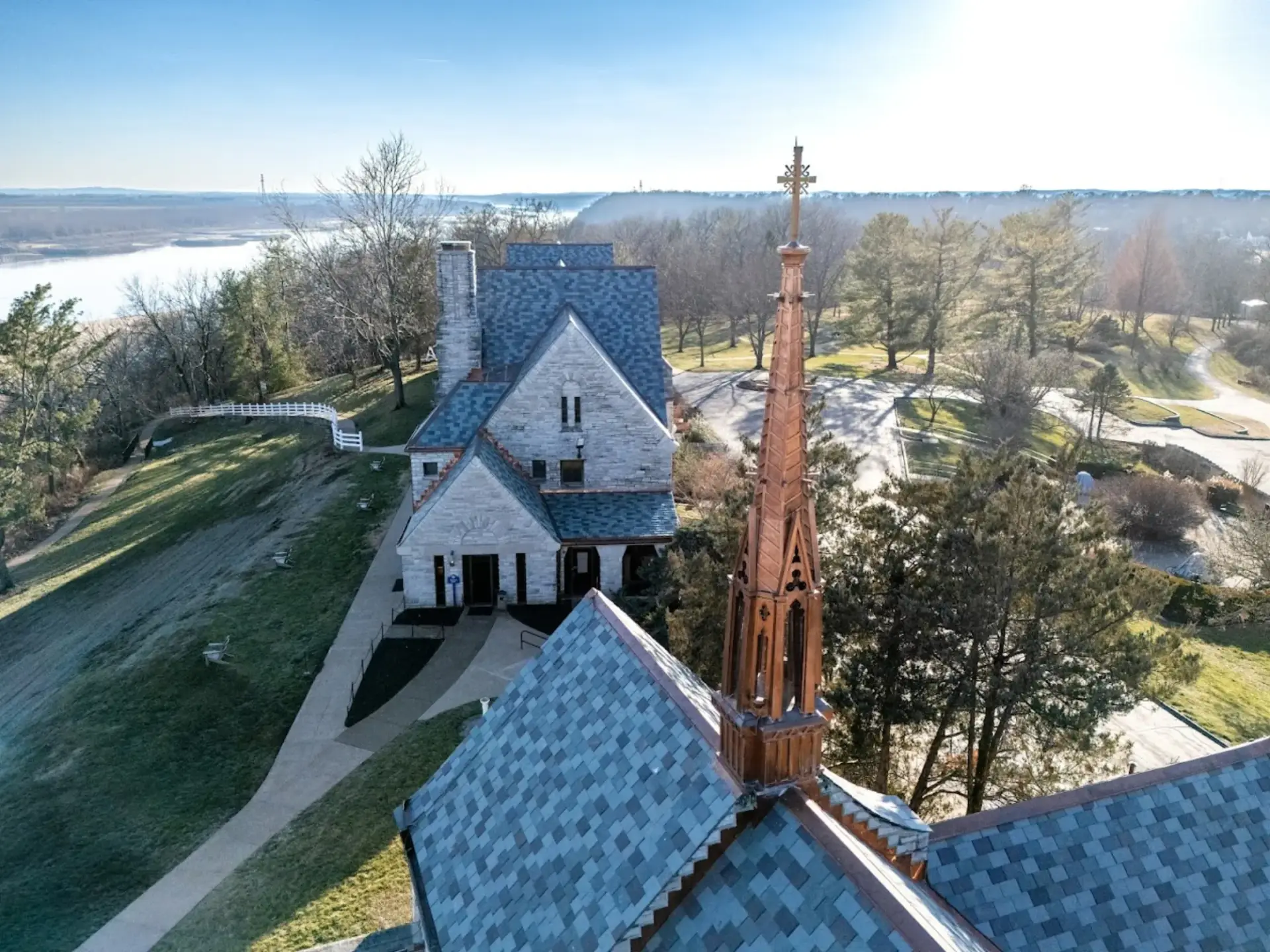 Copper-clad Gothic spire and finial cresting on a riverside stone chapel