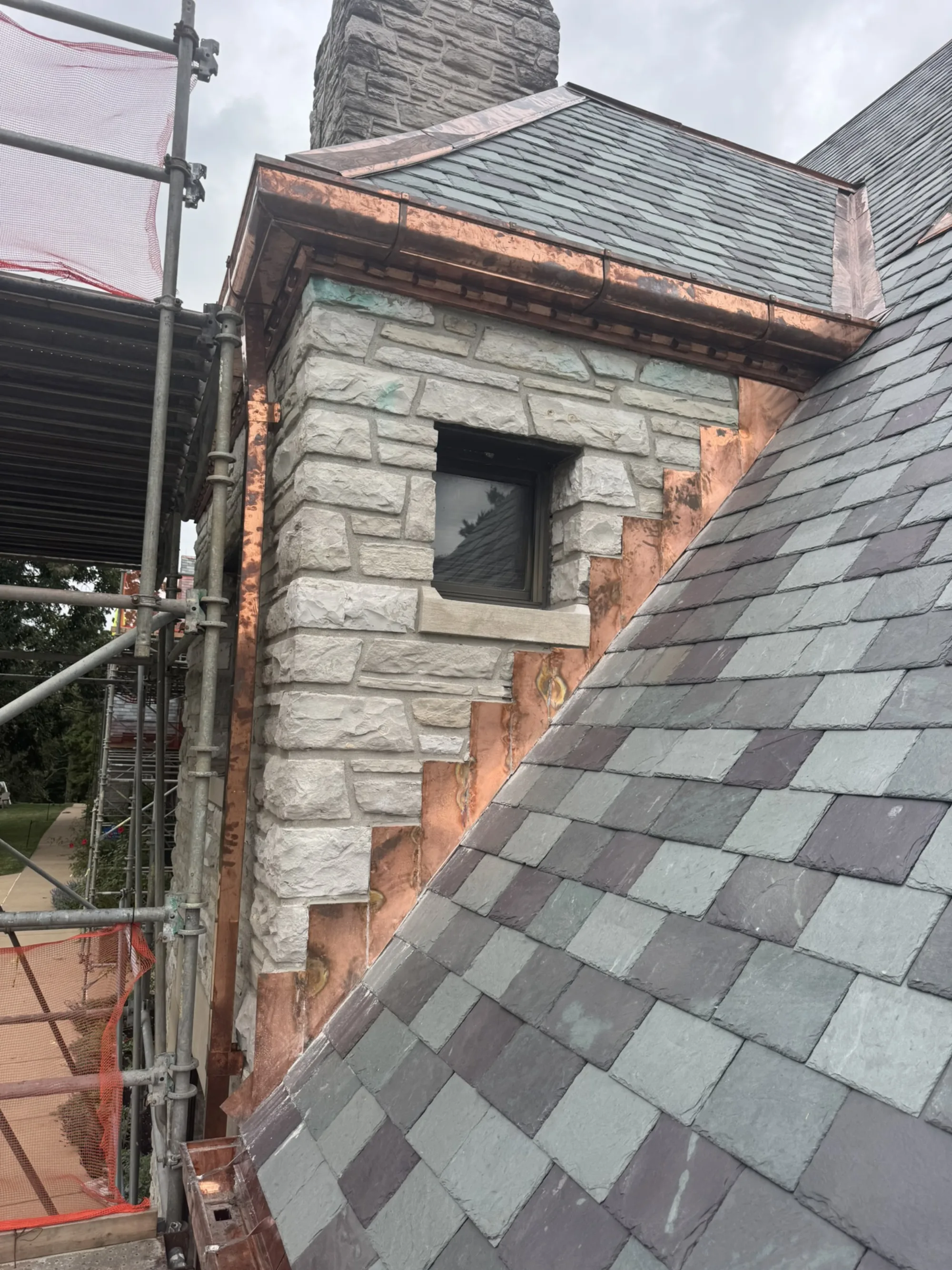 Soldered copper flashing detailed around a dormer, the copper-valley work the Central West End's slate-and-tile mansions require