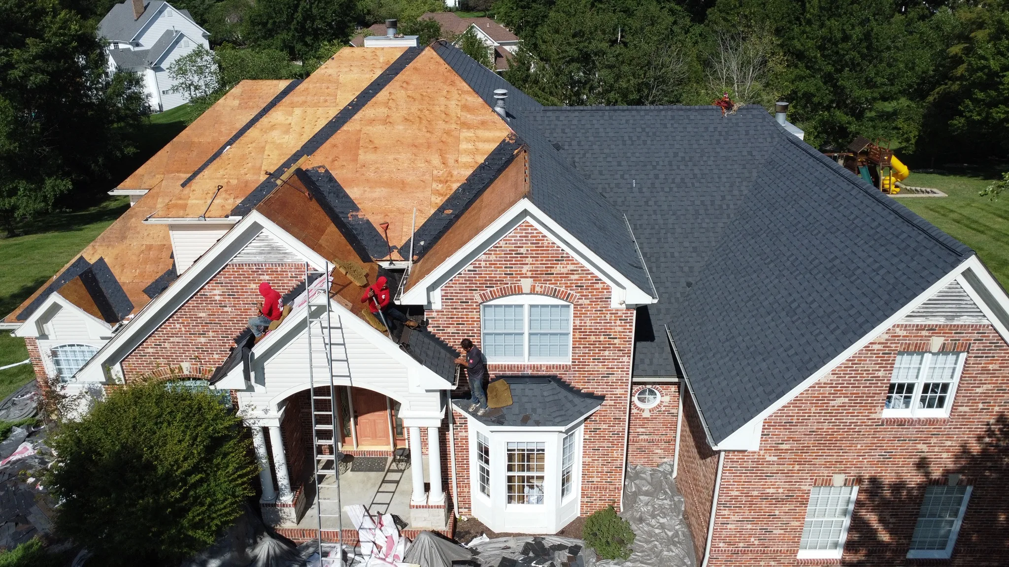 Roof mid tear-off with crew on the deck