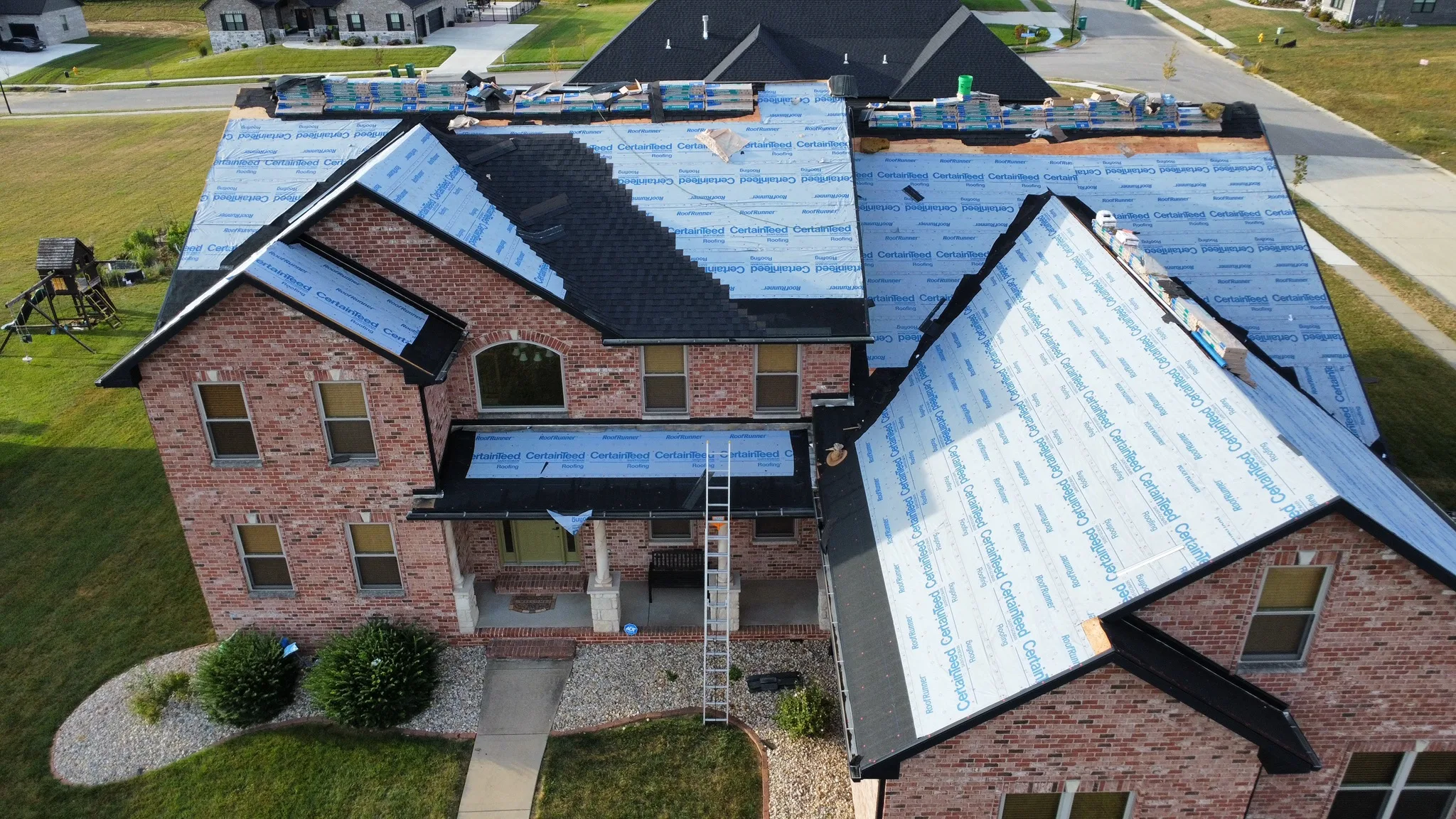 Synthetic underlayment rolled across roof decking