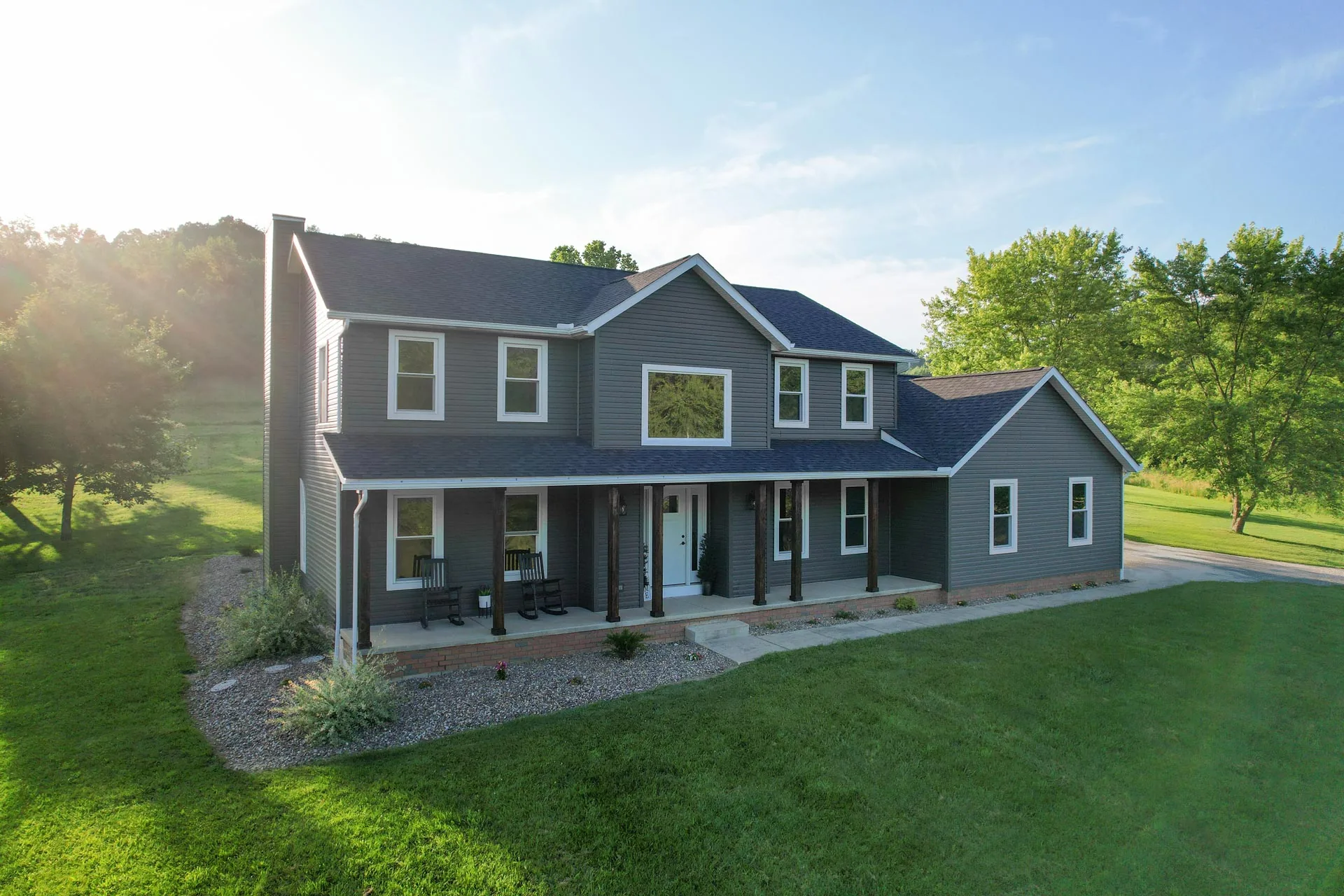 Two-story home clad in charcoal HeartTech vinyl lap siding with a full covered porch