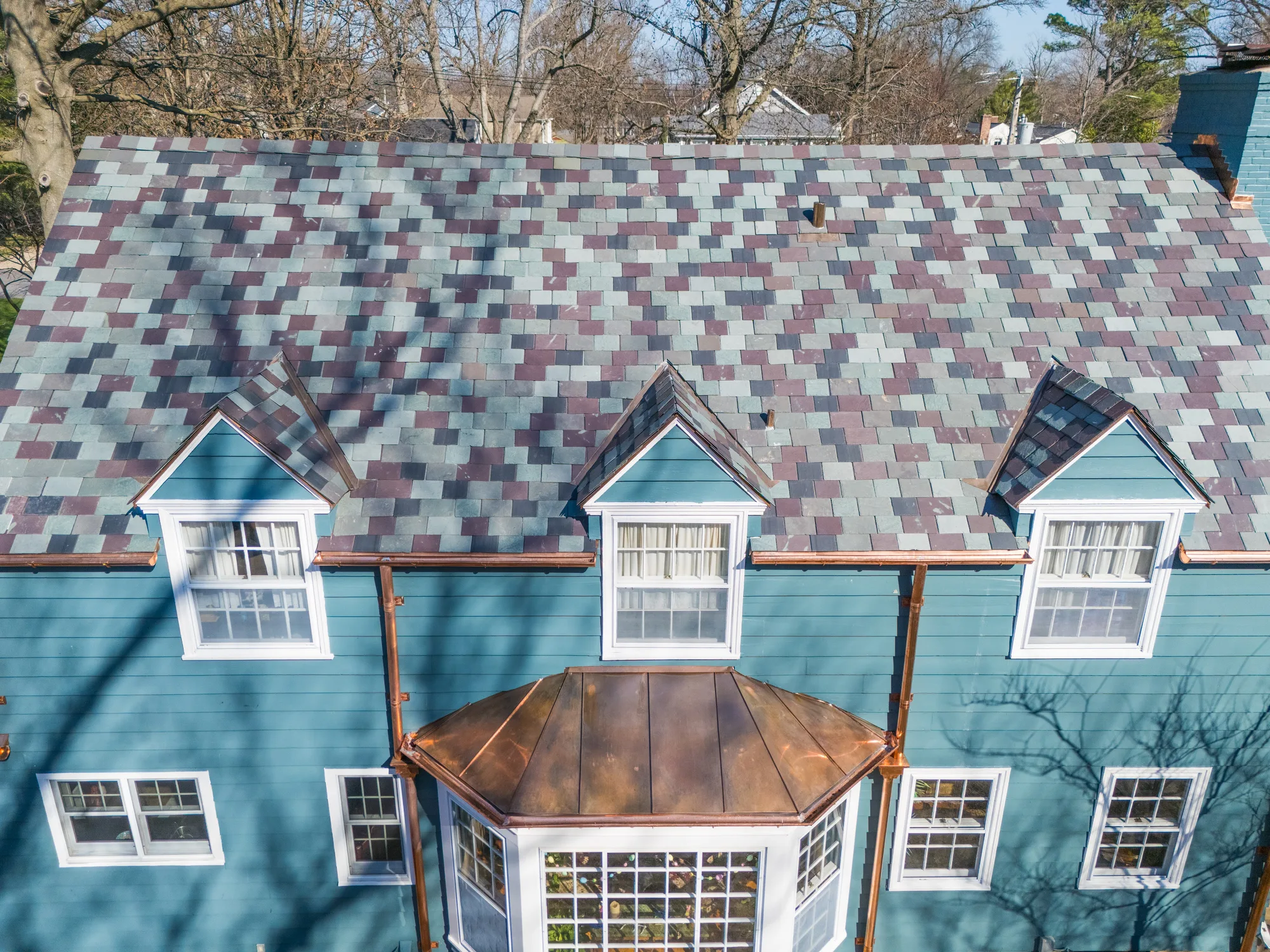 Overhead of the dormers and copper-topped bay window under new variegated slate