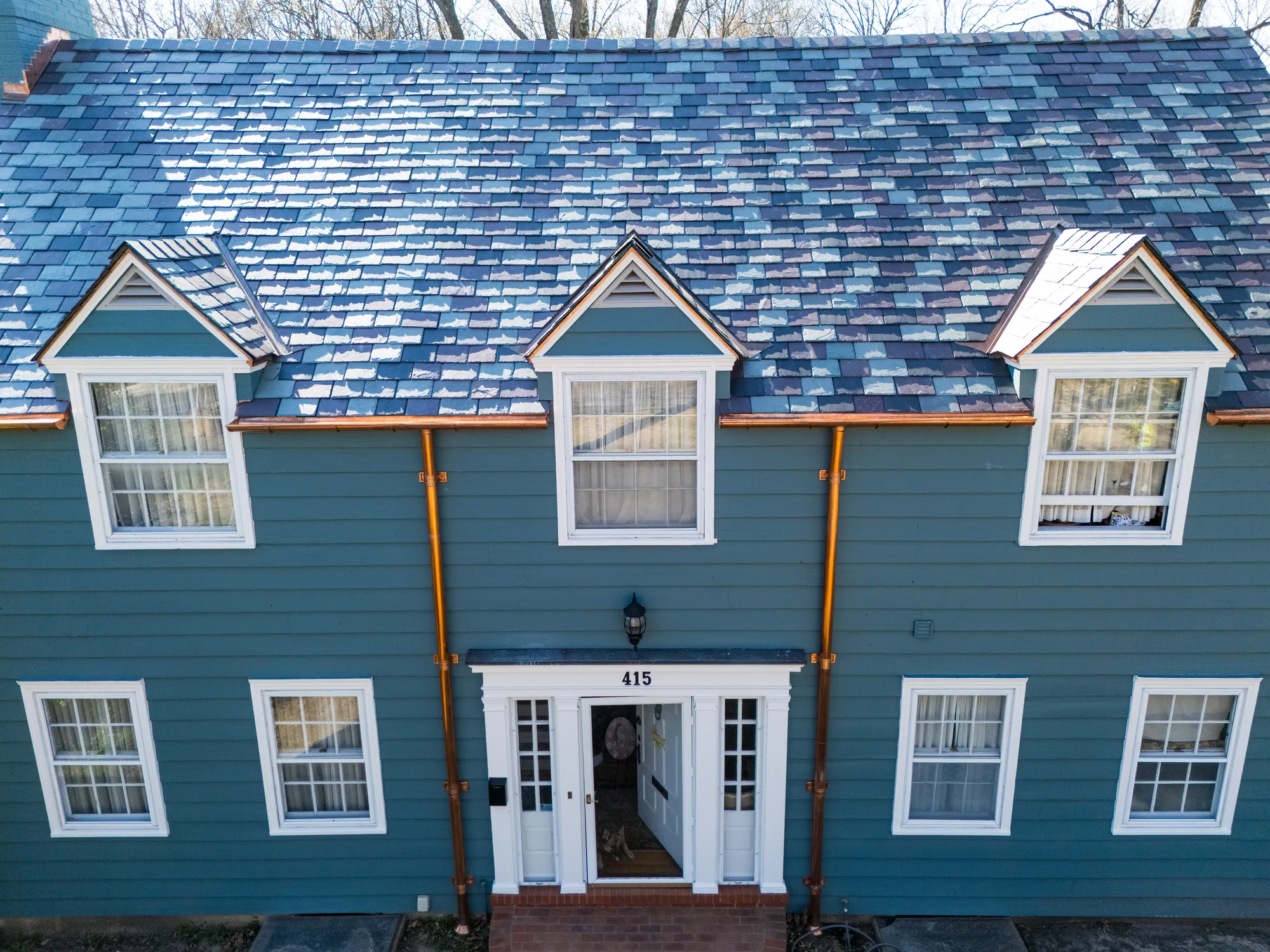 Front facade of the colonial beneath its finished slate roof