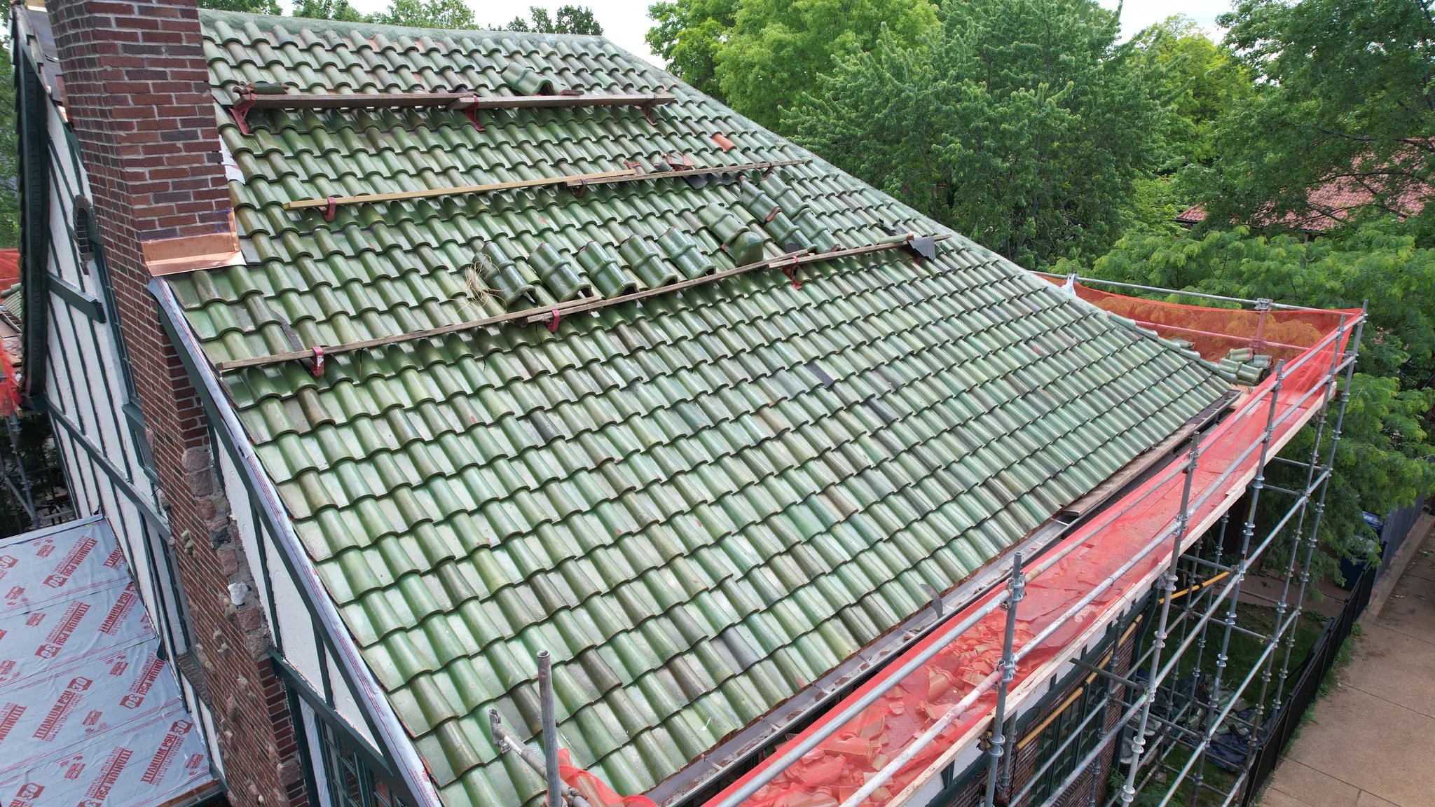 Close aerial of glazed green barrel clay tiles being set course by course