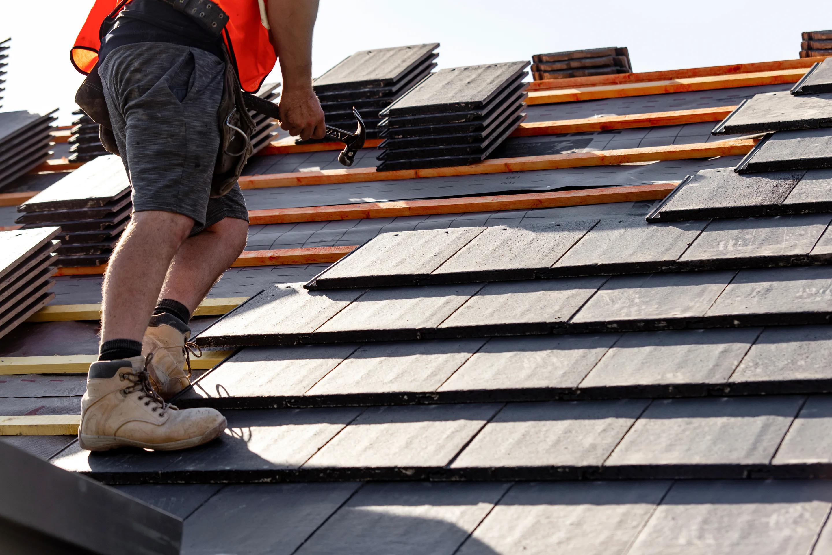 Stacked slate tiles next to a craftsman's boots