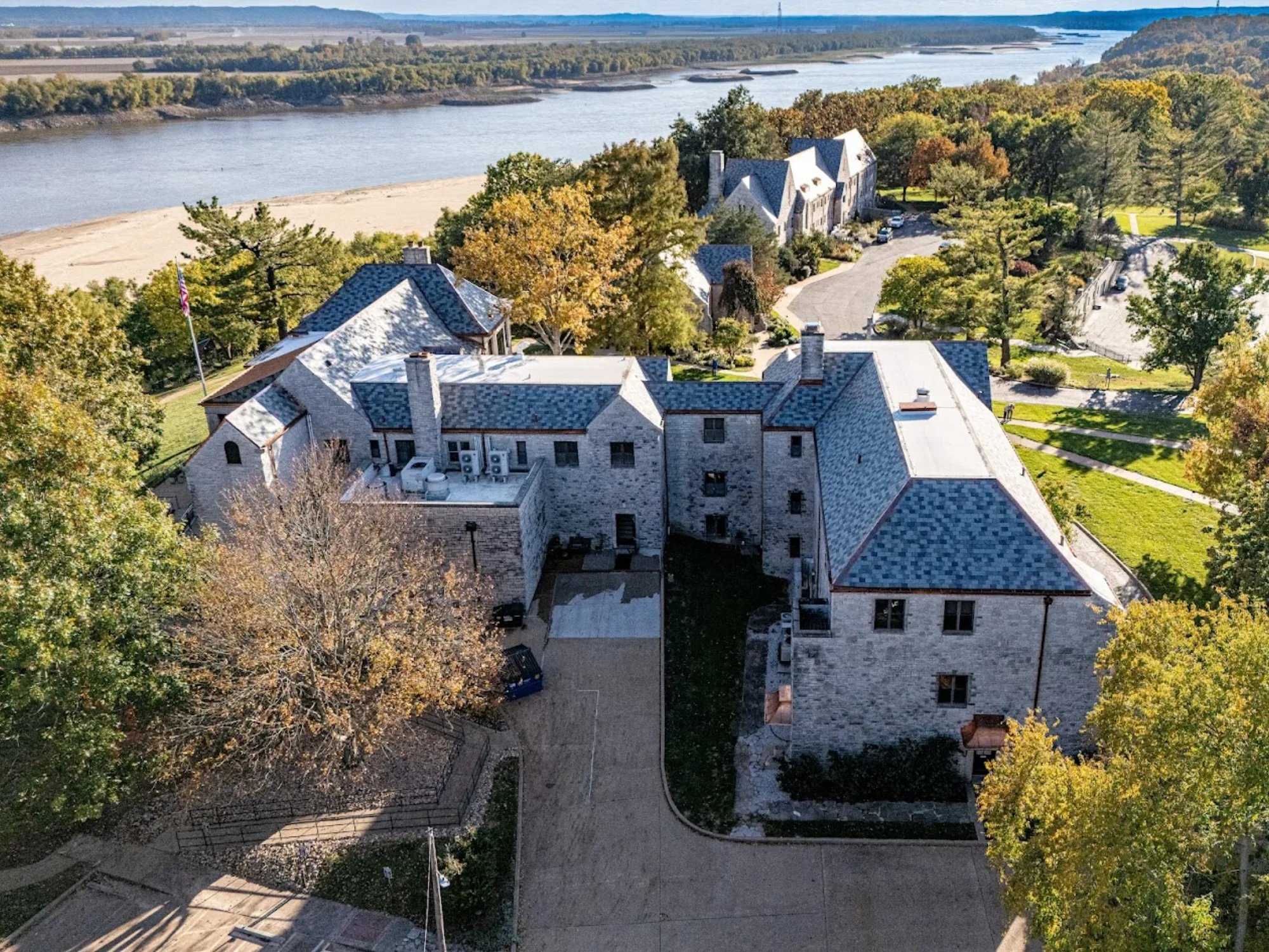 Wide aerial of a finished natural slate roof on a historic estate, the mansard-and-deck system common in Lafayette Square