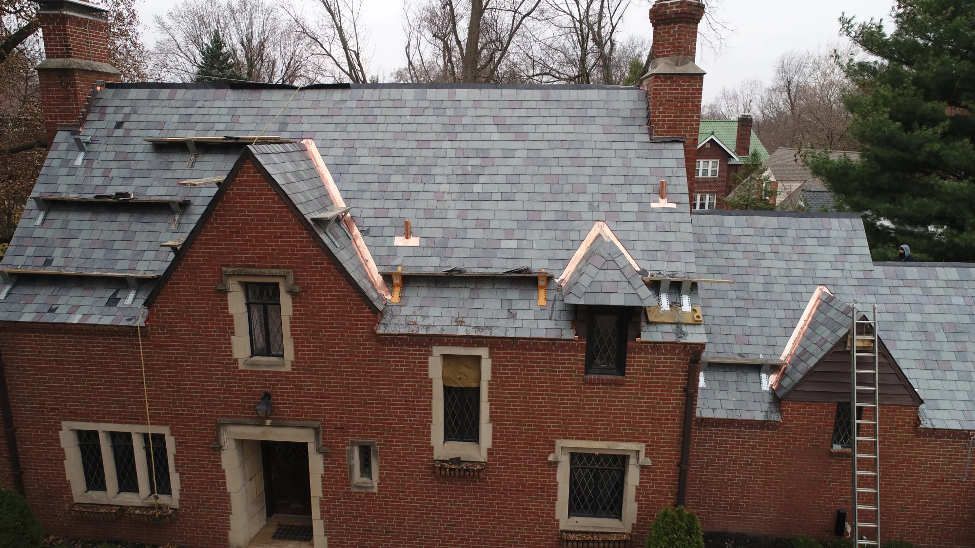 Aerial of a steep slate roof on a historic Tower Grove brick home
