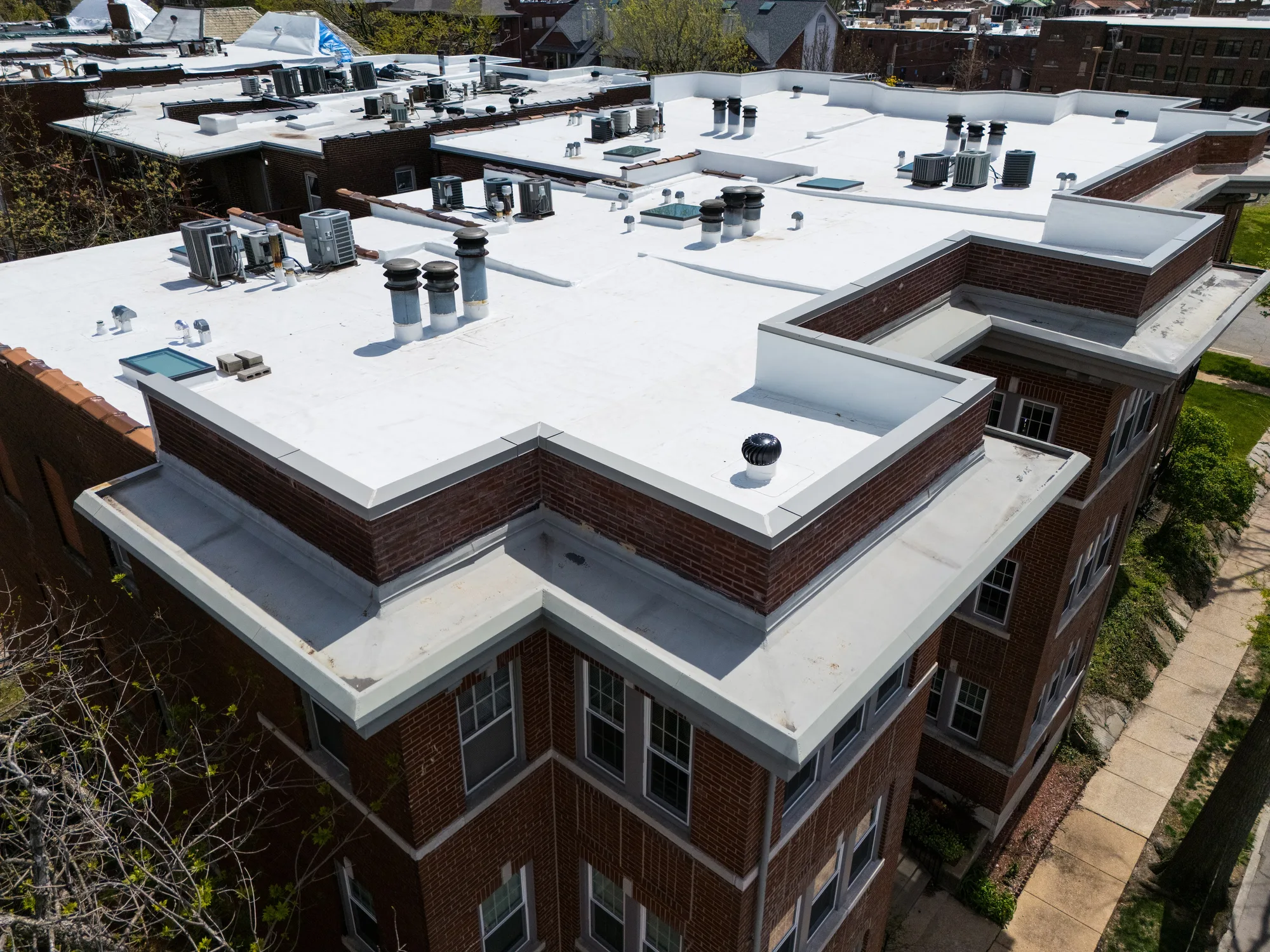 Membrane wrapped clean at the parapet corner of the brick apartment building