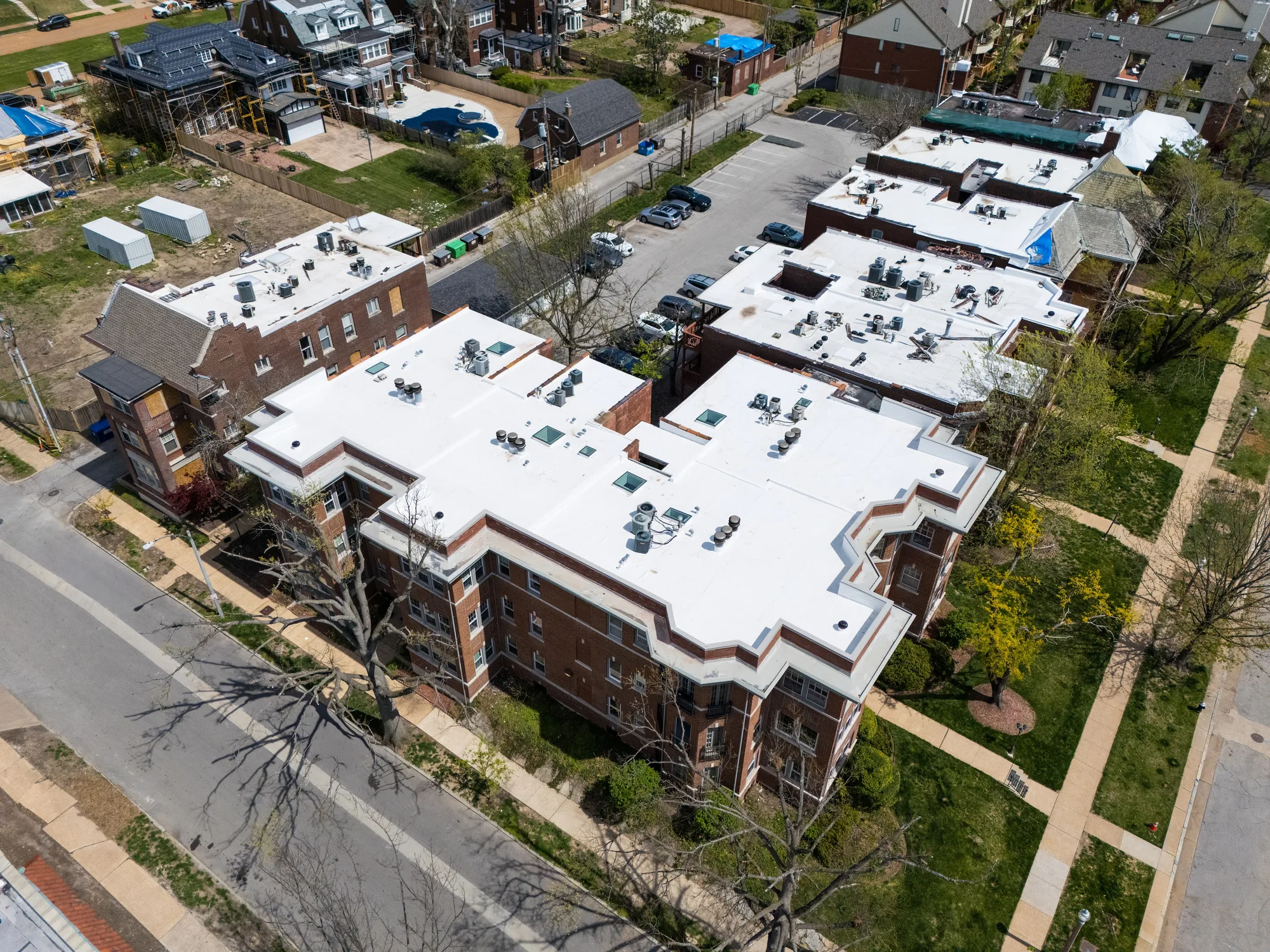Three-quarter aerial of the apartment building and its finished white roof